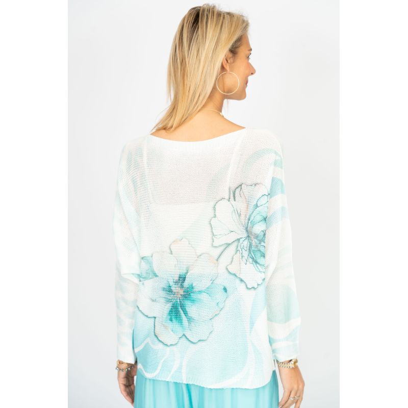 Woman wearing a white blouse with blue floral patterns on a white background