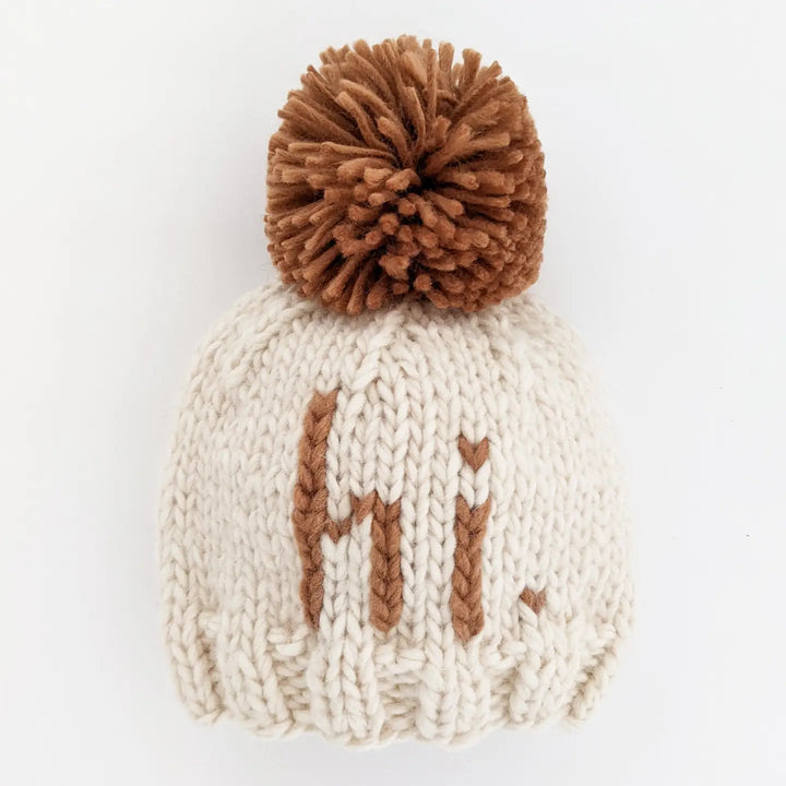 Natural hand-knit Hi There Baby Hat with pecan hi. lettering and pecan pom pom