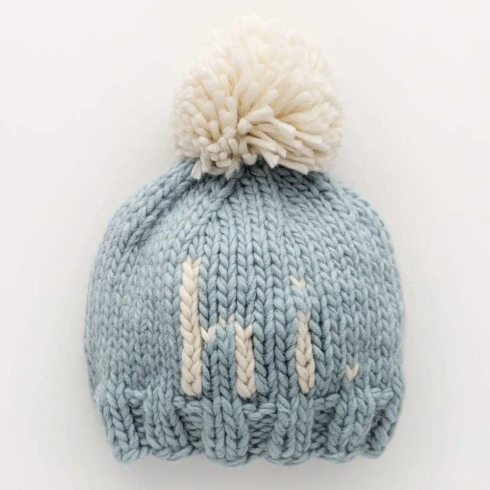 Surf blue hand-knit Hi There Baby Hat with natural hi. lettering and pom pom