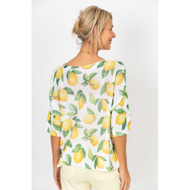 Woman wearing a lemon-patterned blouse on a white background