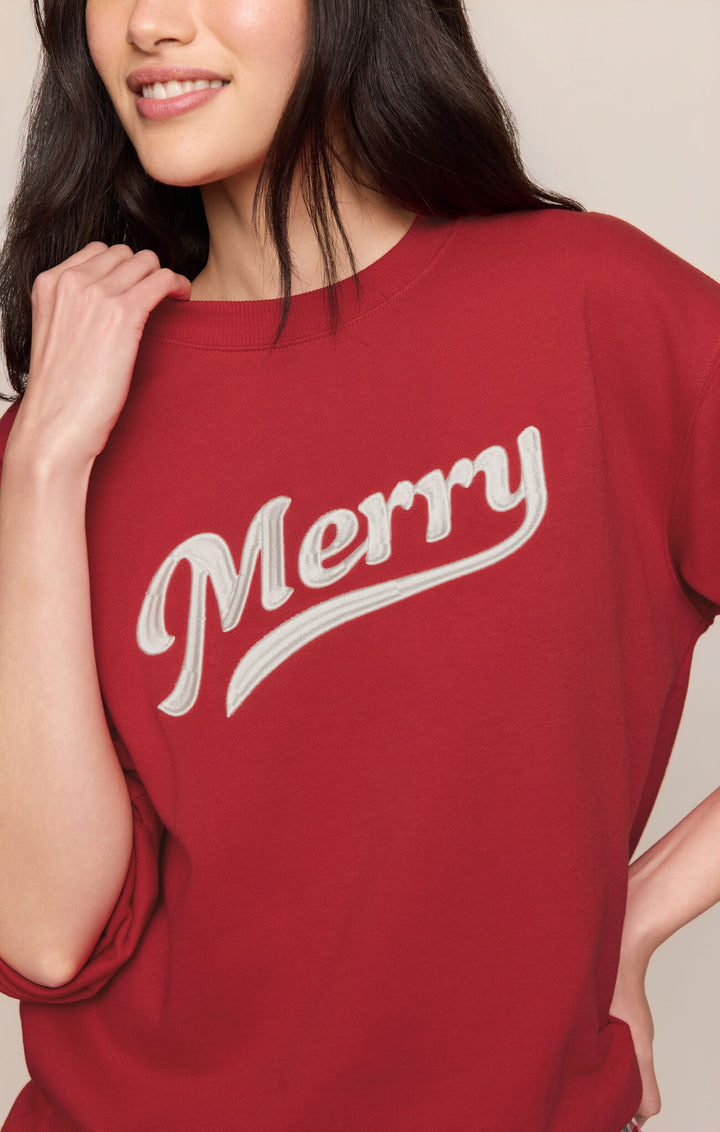 Close-up of the cream "Merry" script graphic on the Ruby Red Z Supply sweatshirt