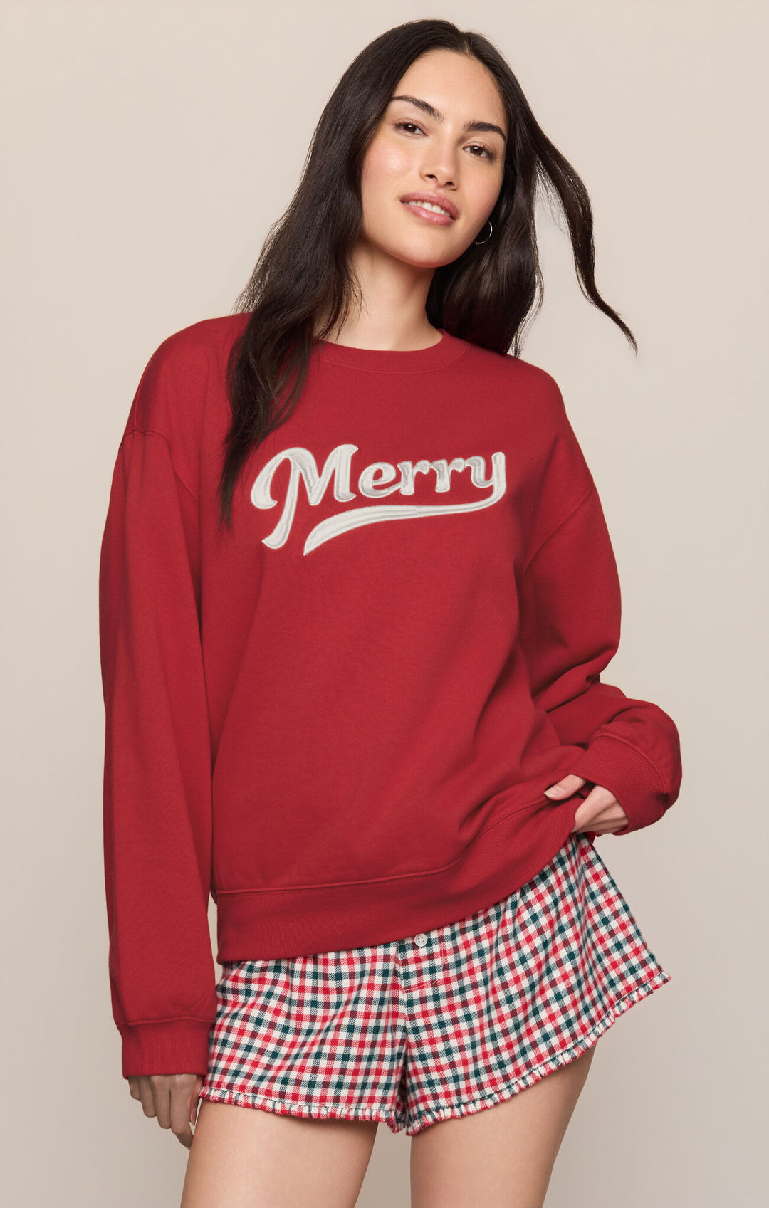Woman wearing the Z Supply Merry Script Sweatshirt in Ruby Red, front view