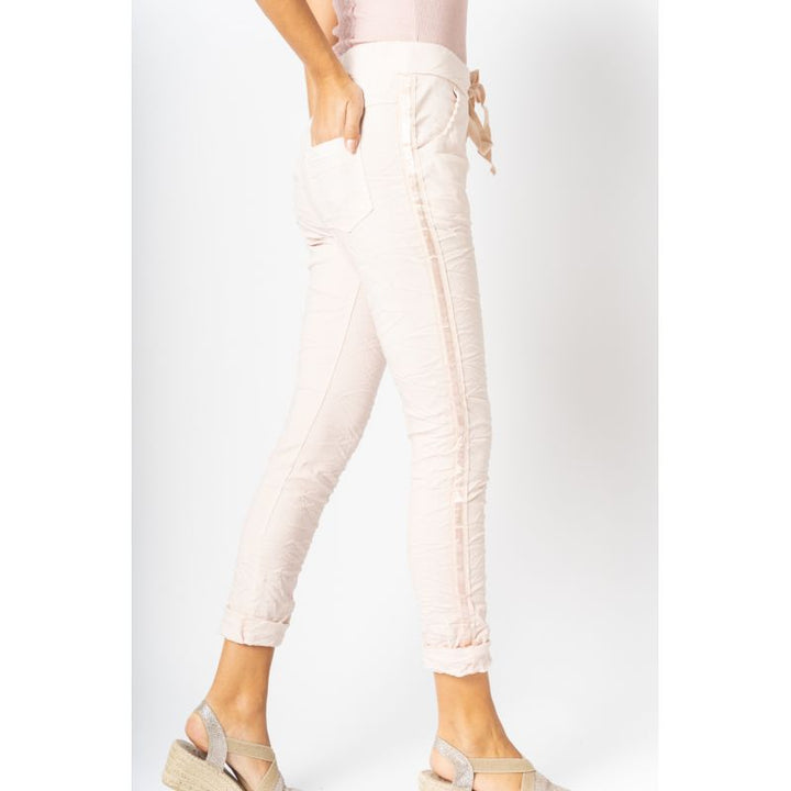 Light pink jeans worn by a person on a white background