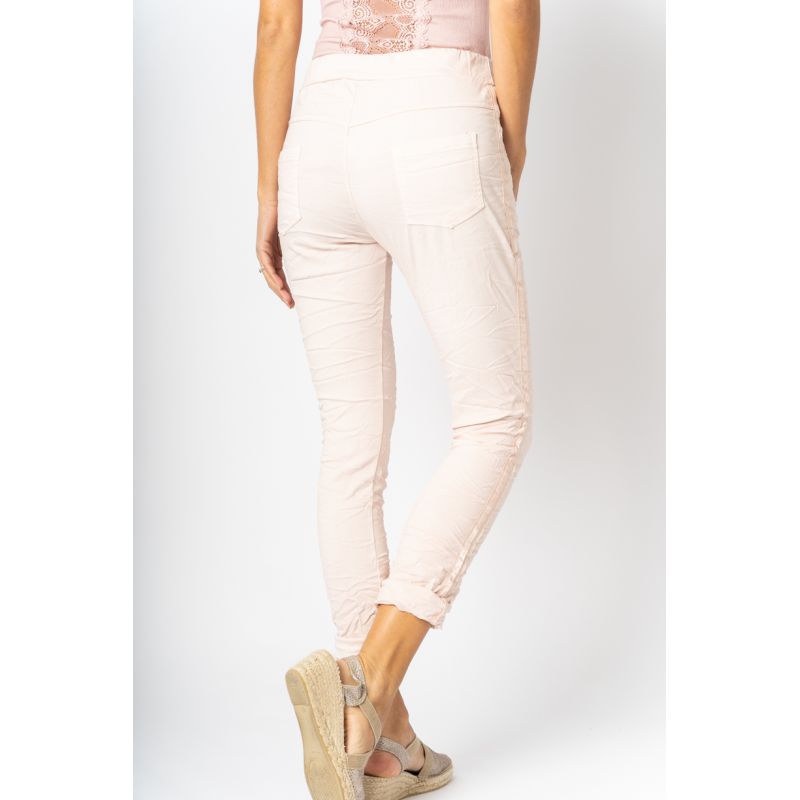 Person wearing light pink pants on a white background