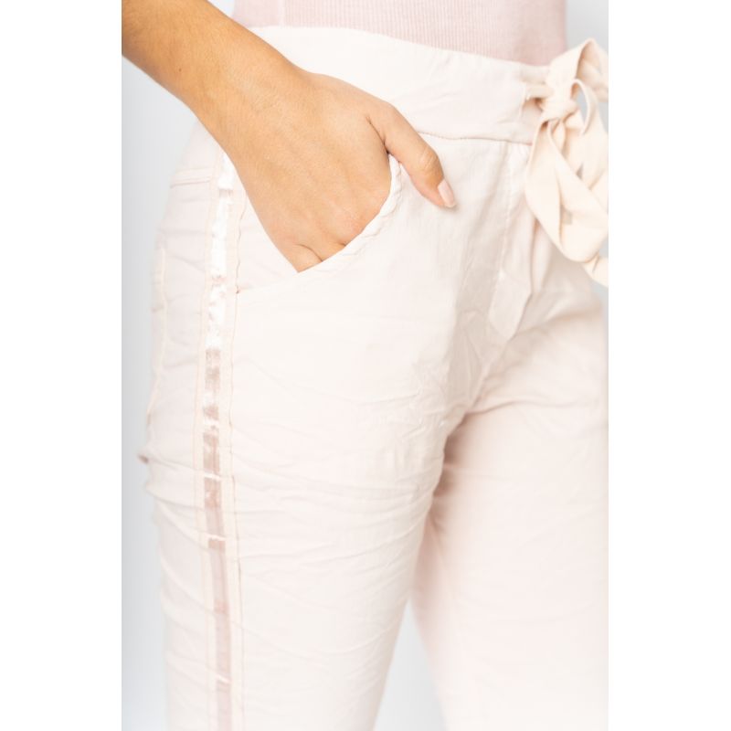 Light pink pants with a subtle pattern on a white background