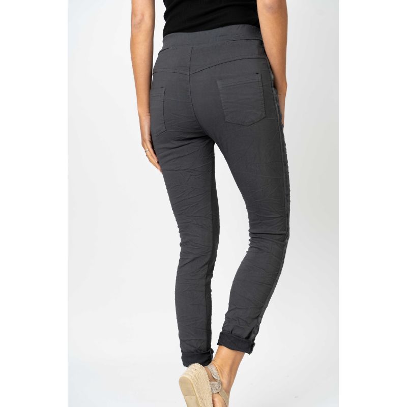 Dark gray pants worn by a person on a white background