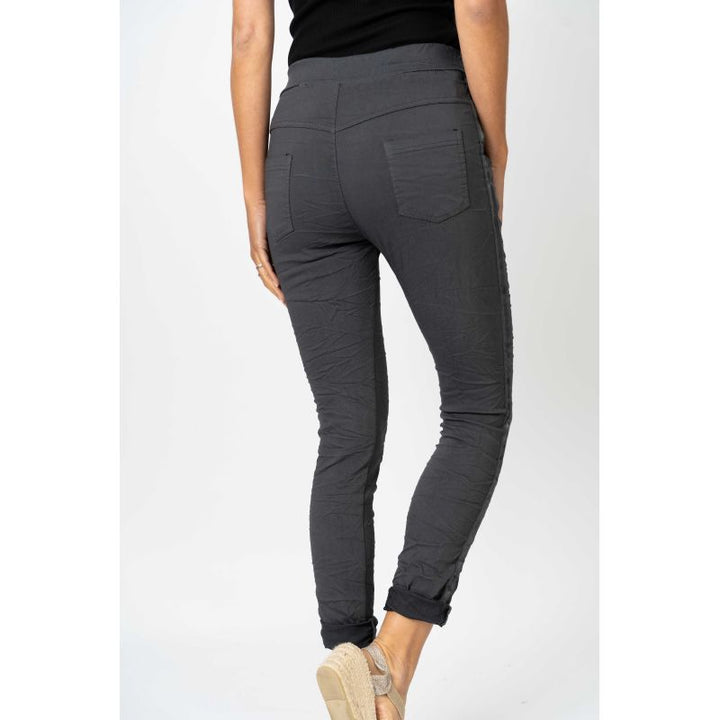 Dark gray pants worn by a person on a white background