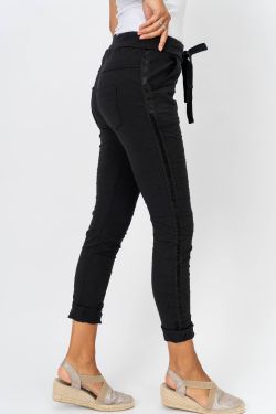 Black jeans worn by a person on a white background
