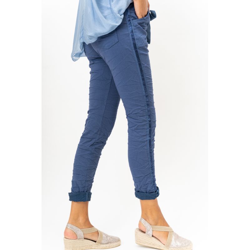 Person wearing blue pants and a light blue top on a white background