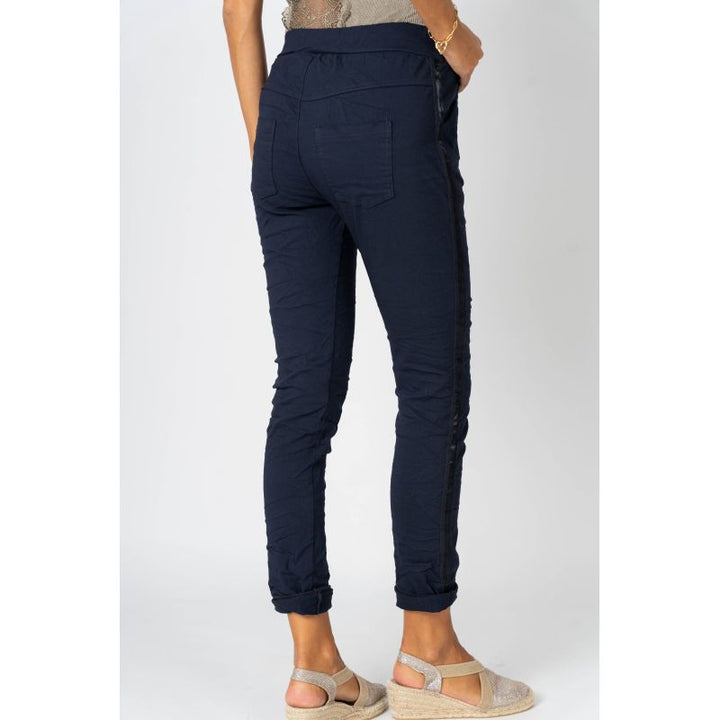 Navy blue jogger pants worn by a person on a white background