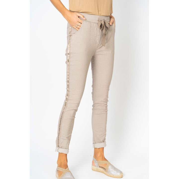 Beige pants worn by a person on a white background