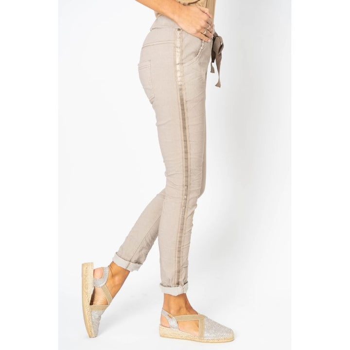 Beige pants worn by a person on a white background