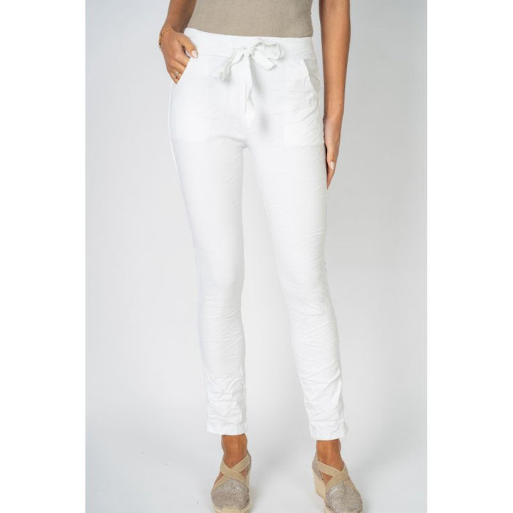 White pants worn by a person on a plain background