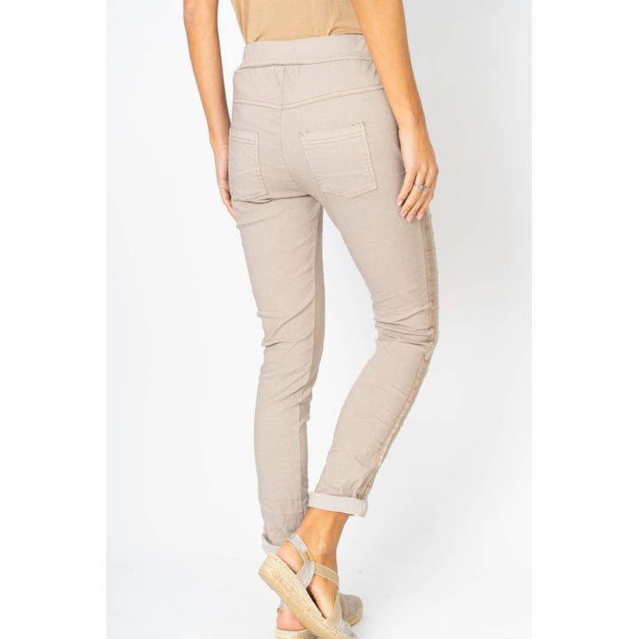 Beige pants worn by a person on a white background