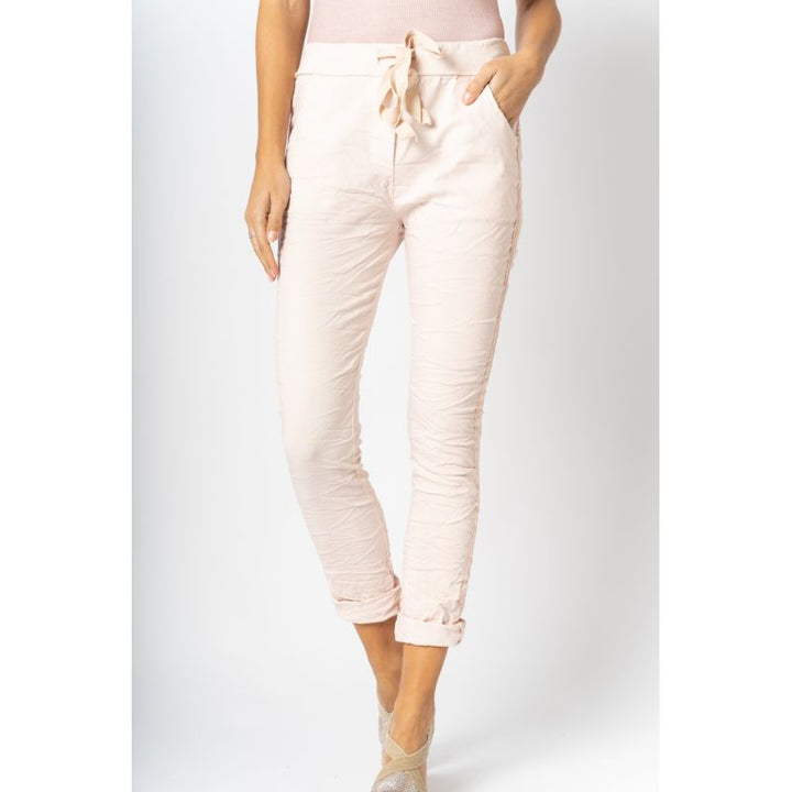 Light pink pants worn by a person on a white background