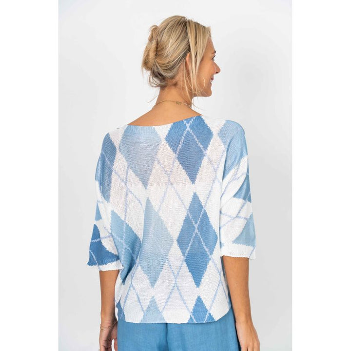 Woman wearing a blue and white patterned sweater on a white background