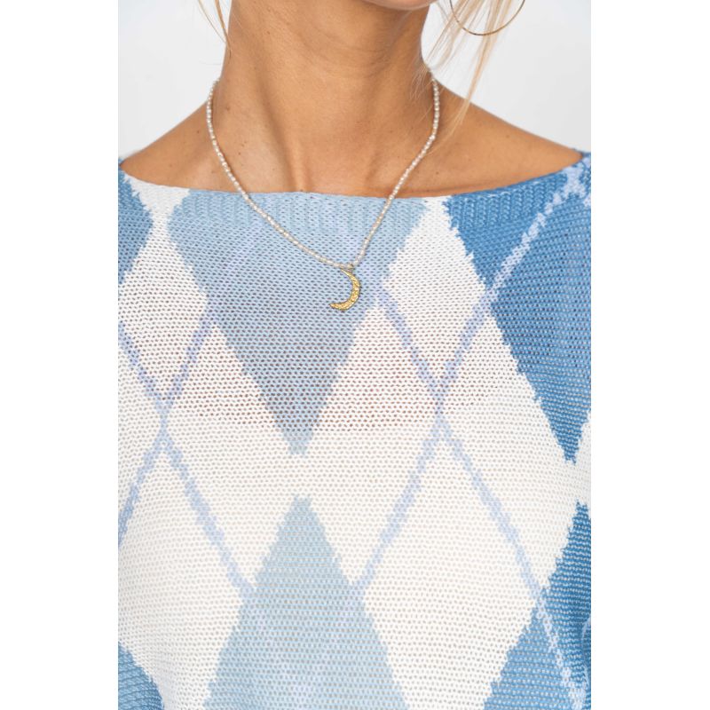 Person wearing a blue and white argyle patterned top with a necklace featuring a moon pendant.