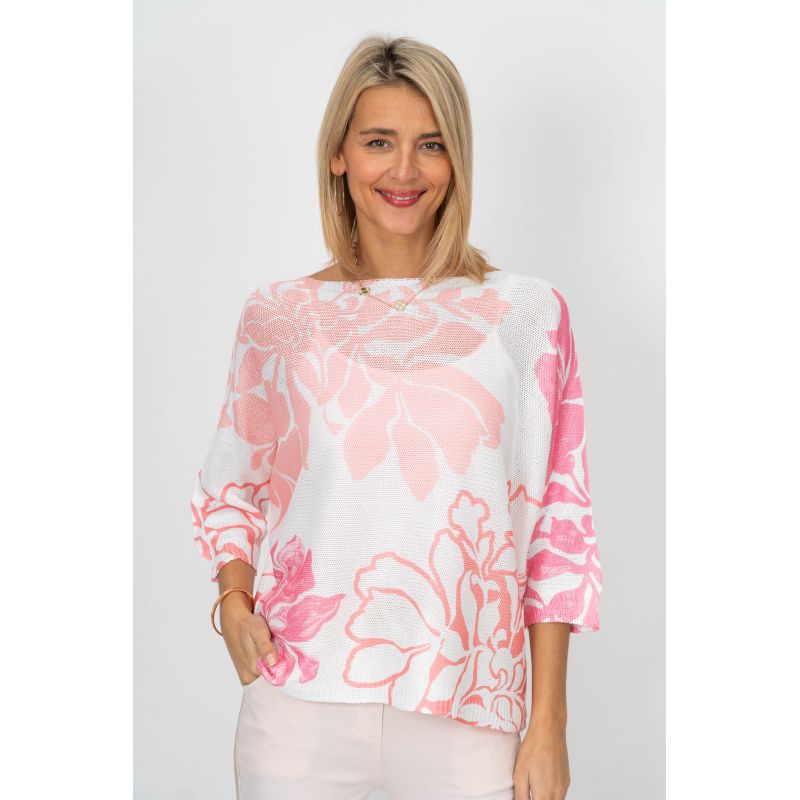 Woman wearing a pink floral blouse against a white background