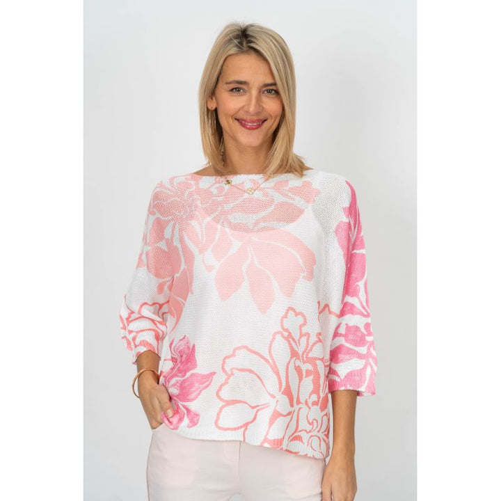 Woman wearing a pink floral blouse against a white background