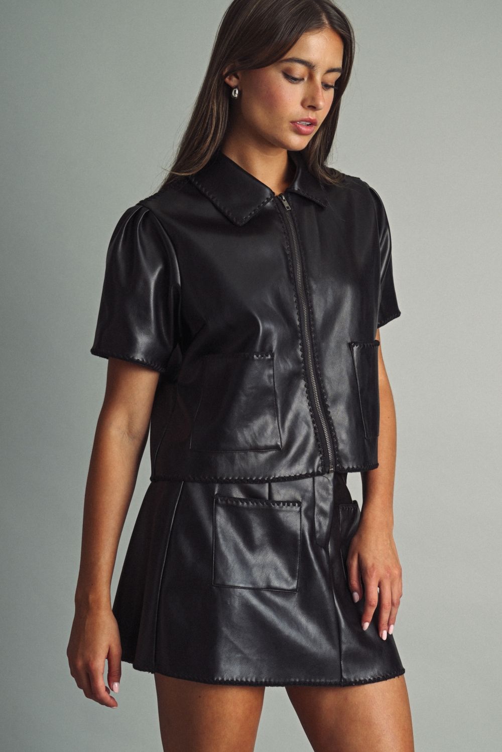 Rhodes Faux Leather Mini Skirt in black, front view styled with the matching Rhodes Faux Leather Zip Top