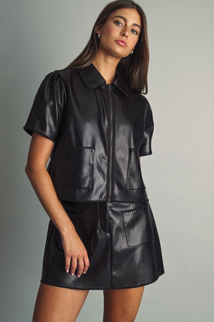 Rhodes Faux Leather Mini Skirt in black, three-quarter view styled with the matching Rhodes Faux Leather Zip Top