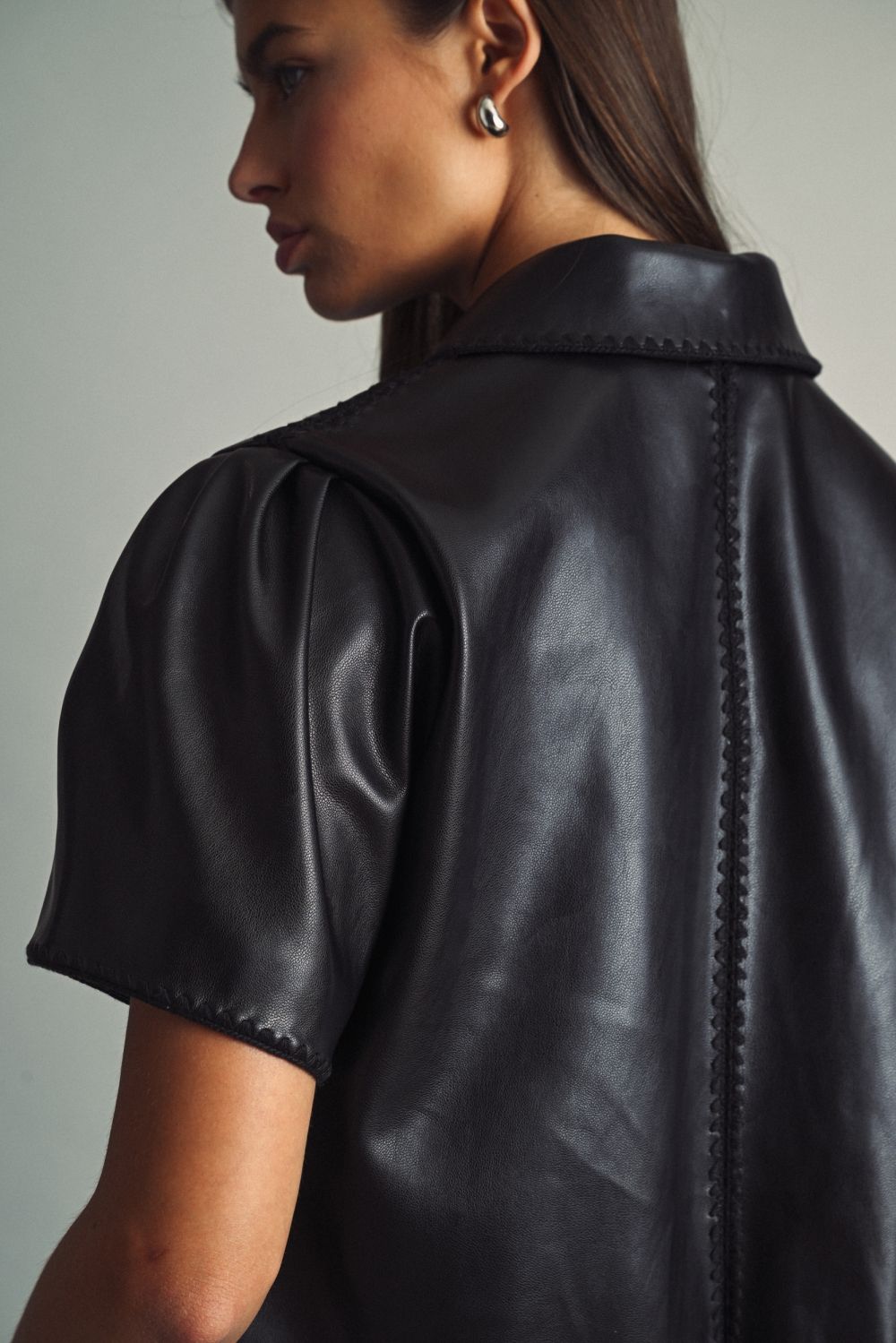 Rhodes Faux Leather Zip Top in black, close-up of puff sleeve and stitched trim