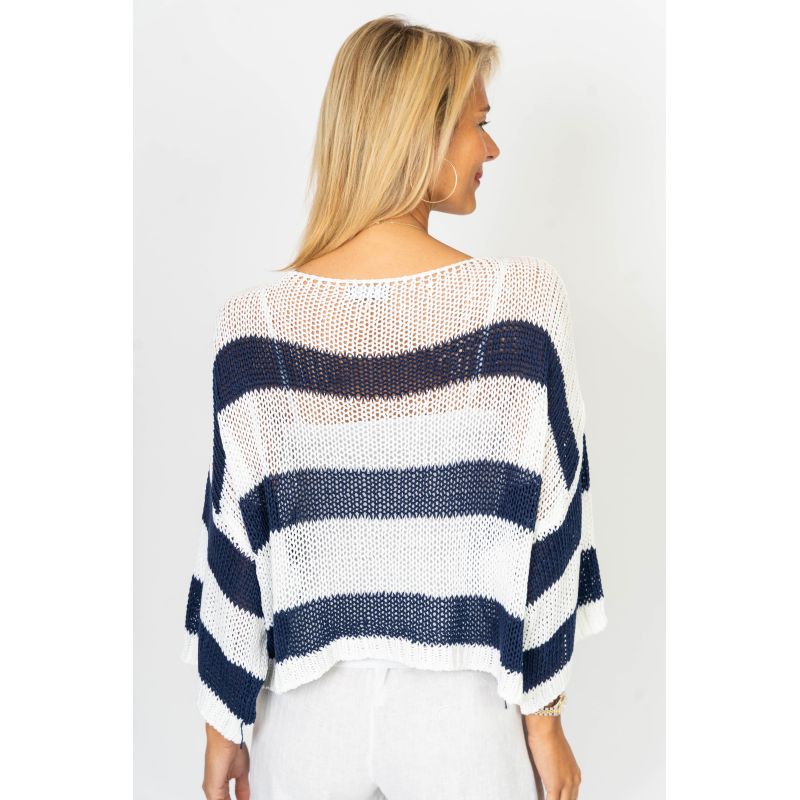 Woman wearing a navy and white striped sweater on a plain background