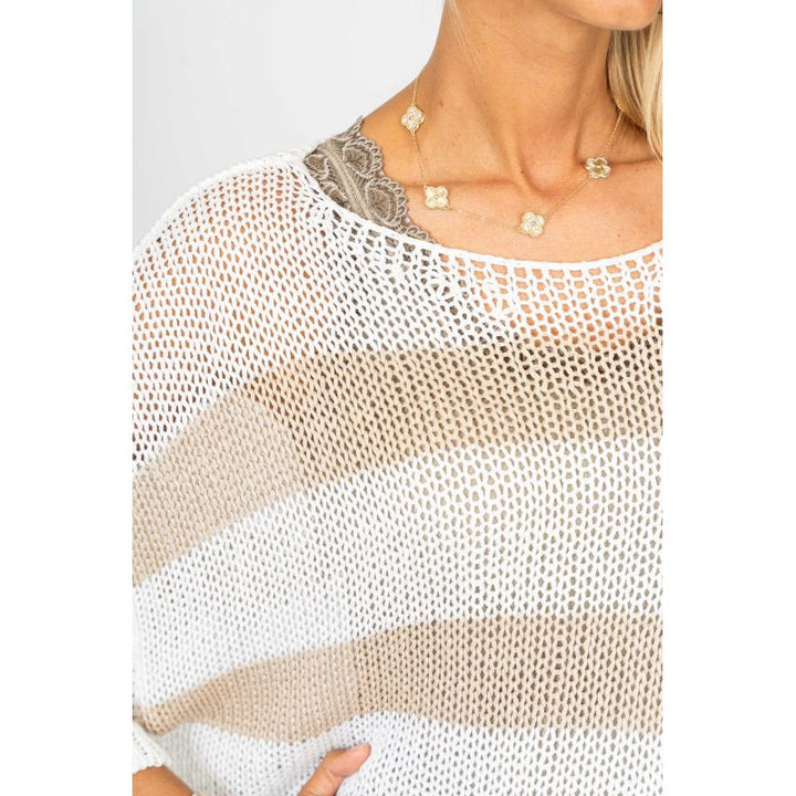 Woman wearing a beige and white mesh top with a plain background