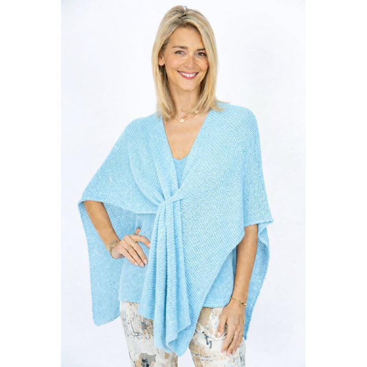 Woman wearing a light blue poncho against a white background