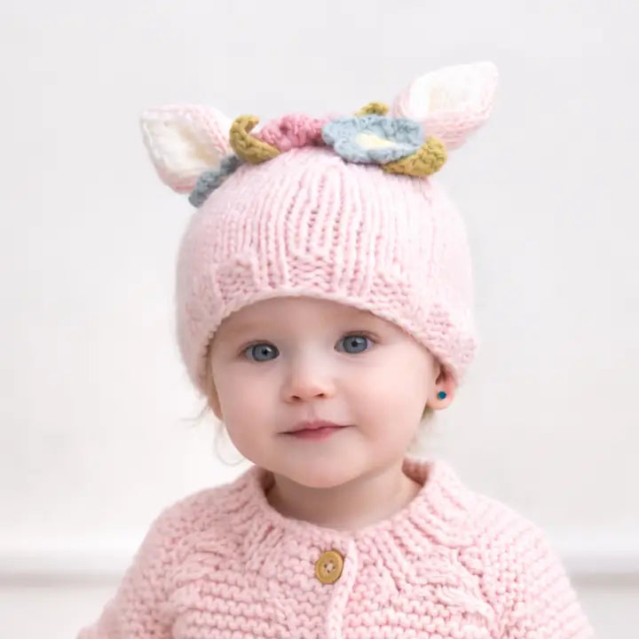 Toddler wearing the blush Wildflower Bunny Baby Hat with pink, blue and yellow flowers